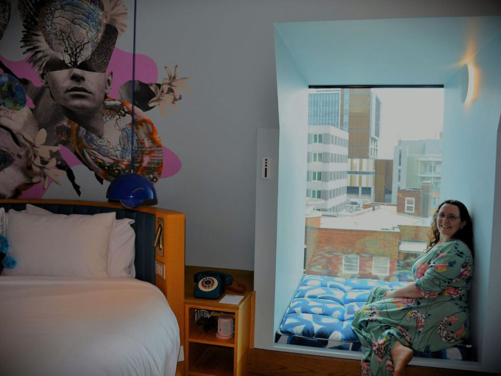 Author Ann-Marie seating at a window nook in a room at 25hours Hotel Sydney The Olympia