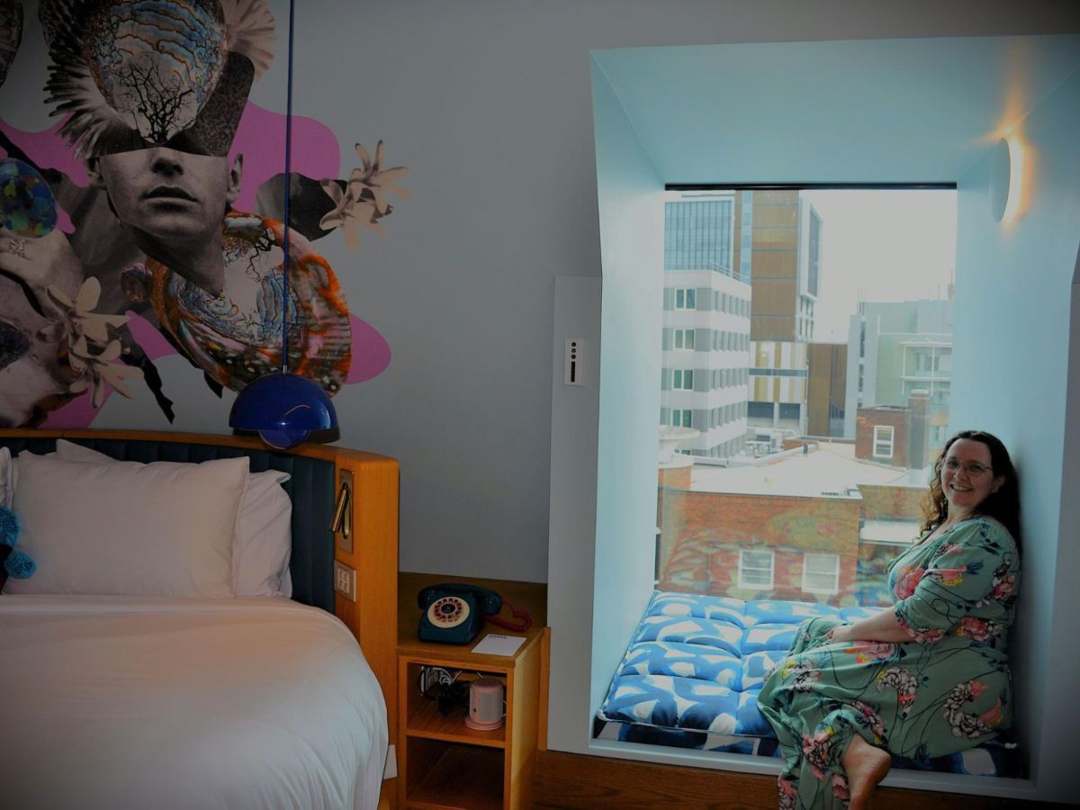 Author Ann-Marie seating at a window nook in a room at 25hours Hotel Sydney The Olympia