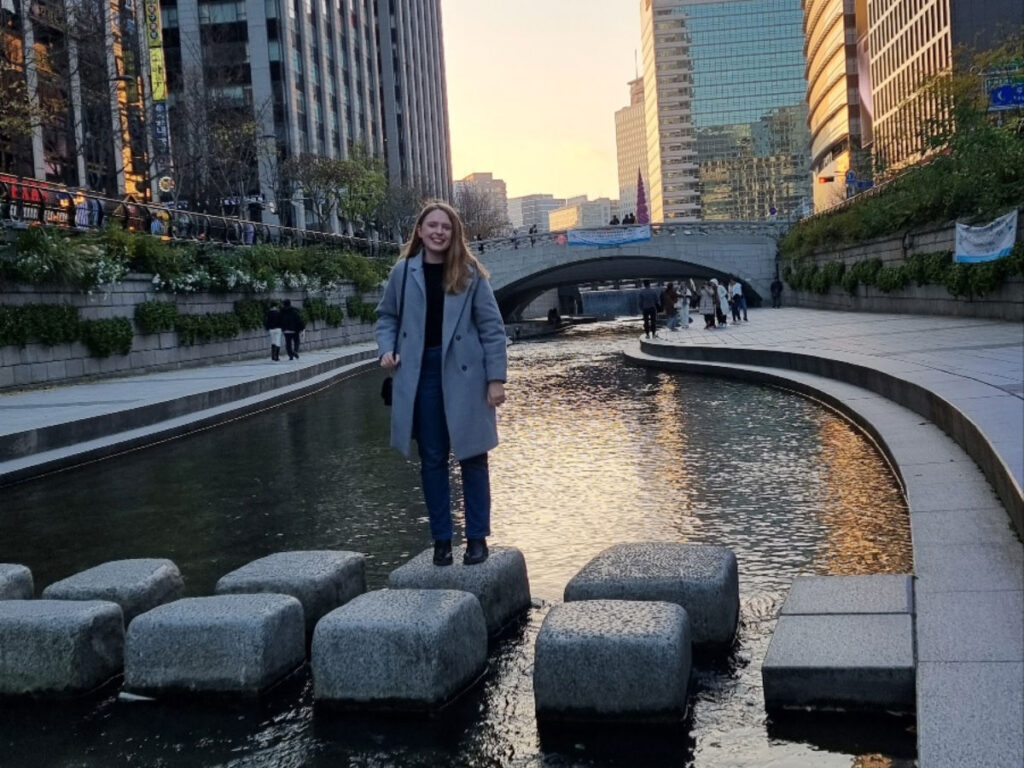 Author Bethan standing on a rock at the Cheonggyecheon stream