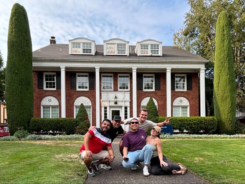 Author Betty and crew posing in front of the Animal House by U of O