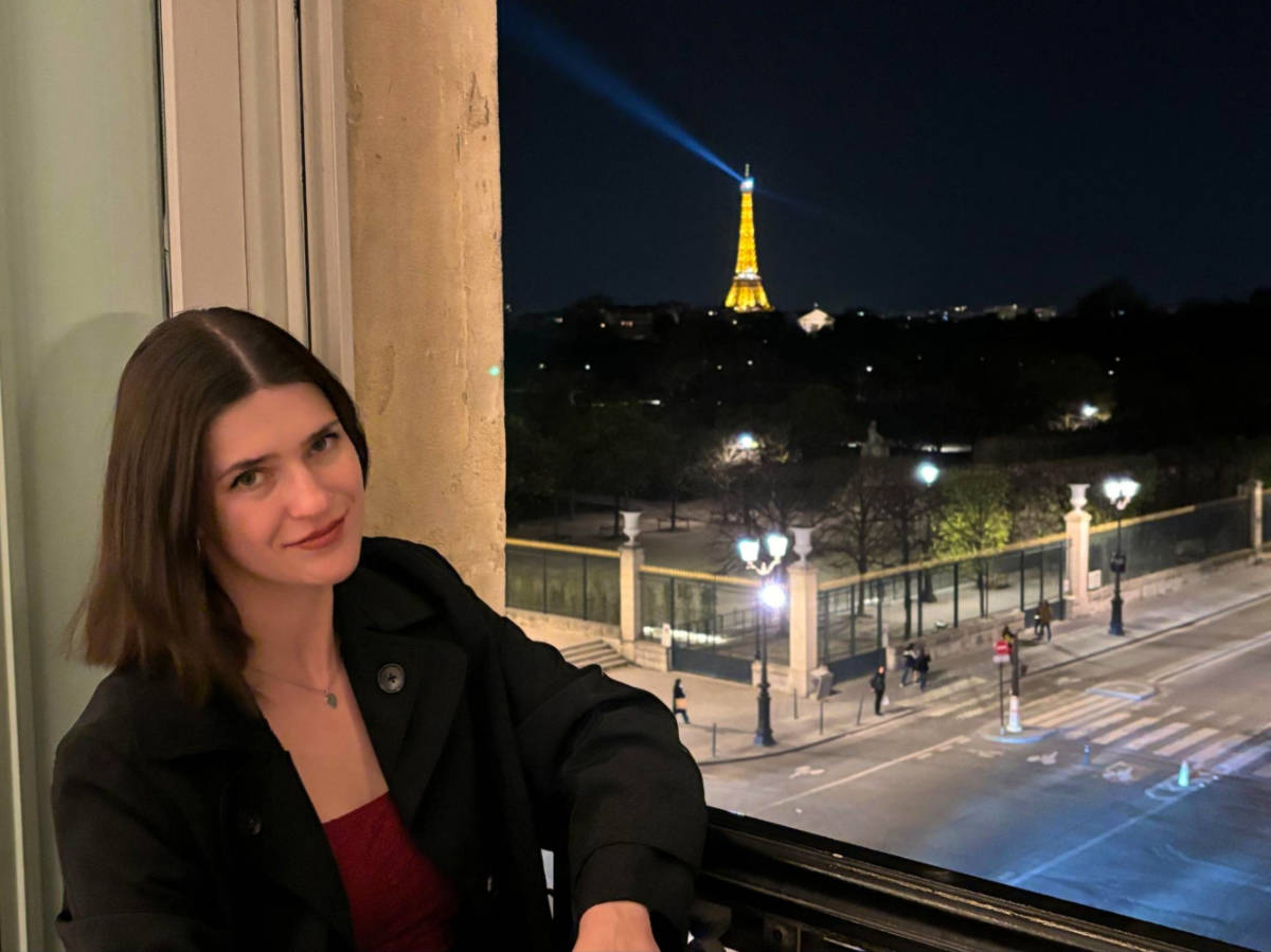 Author Betty lounging in the window of their family suite at Hotel Regina Louvre at night