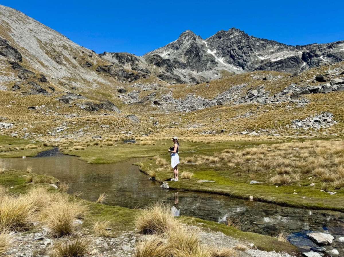 Author Betty standing at a river along the way to Lake Alta