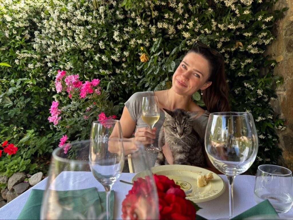 Author Betty enjoying some wine while holding a cat