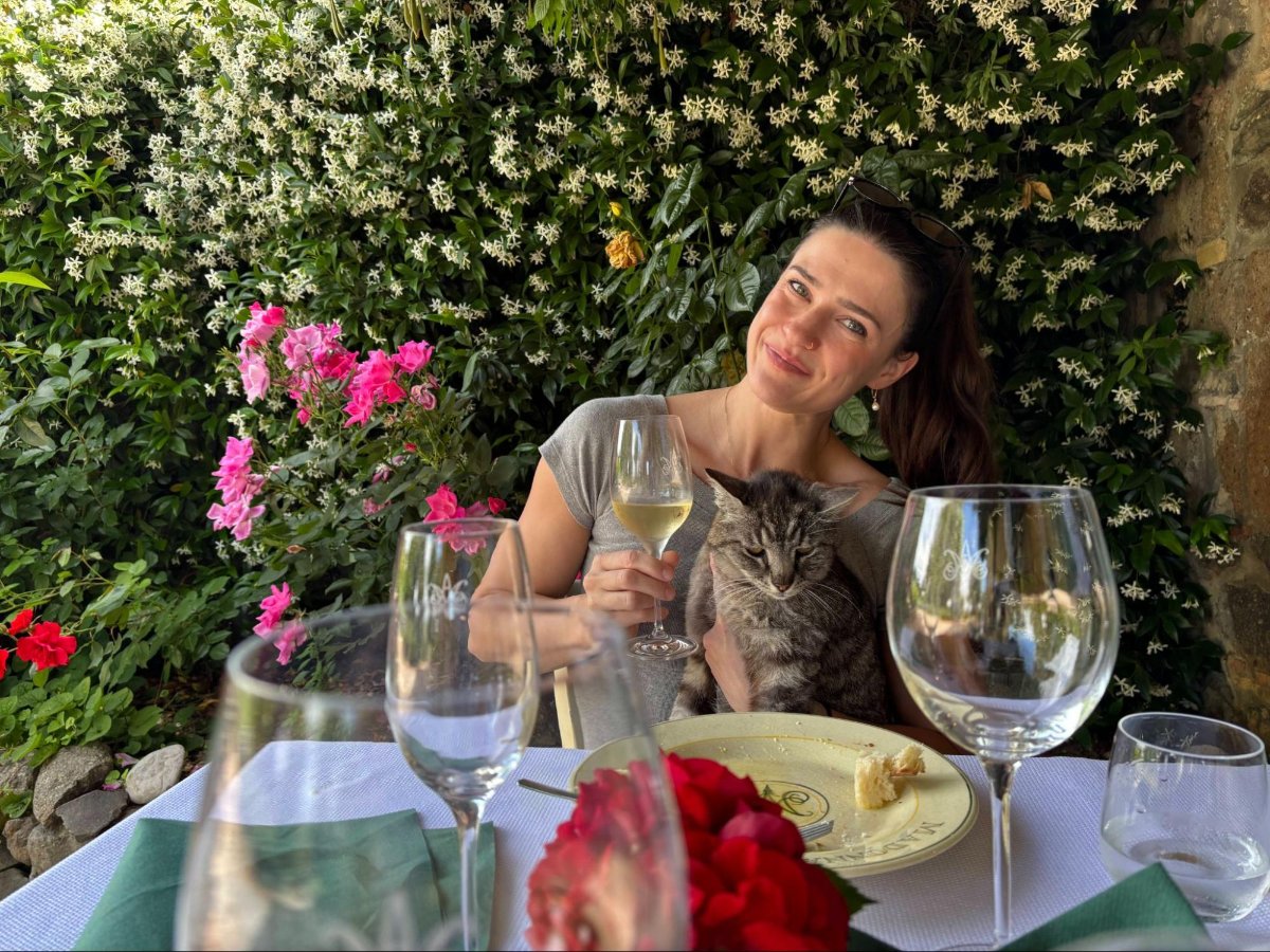Author Betty enjoying some wine while holding a cat