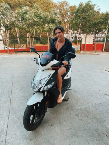 Author Betty sitting on a moped