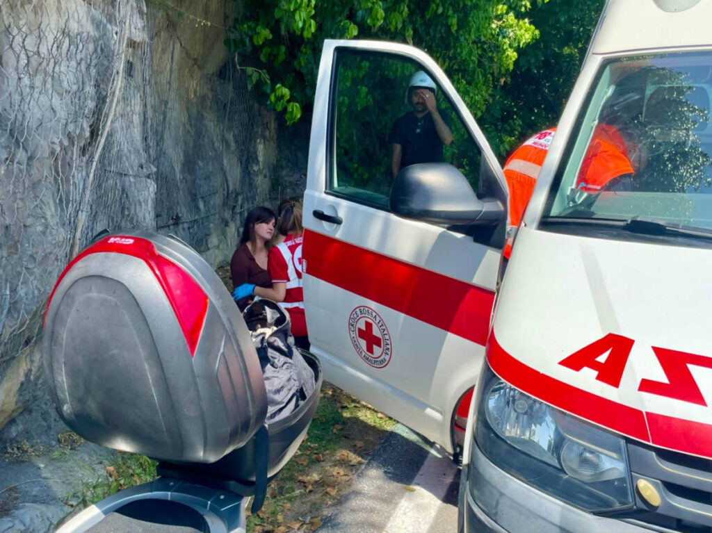 An ambulance parked beside a motorcycle with paramedics