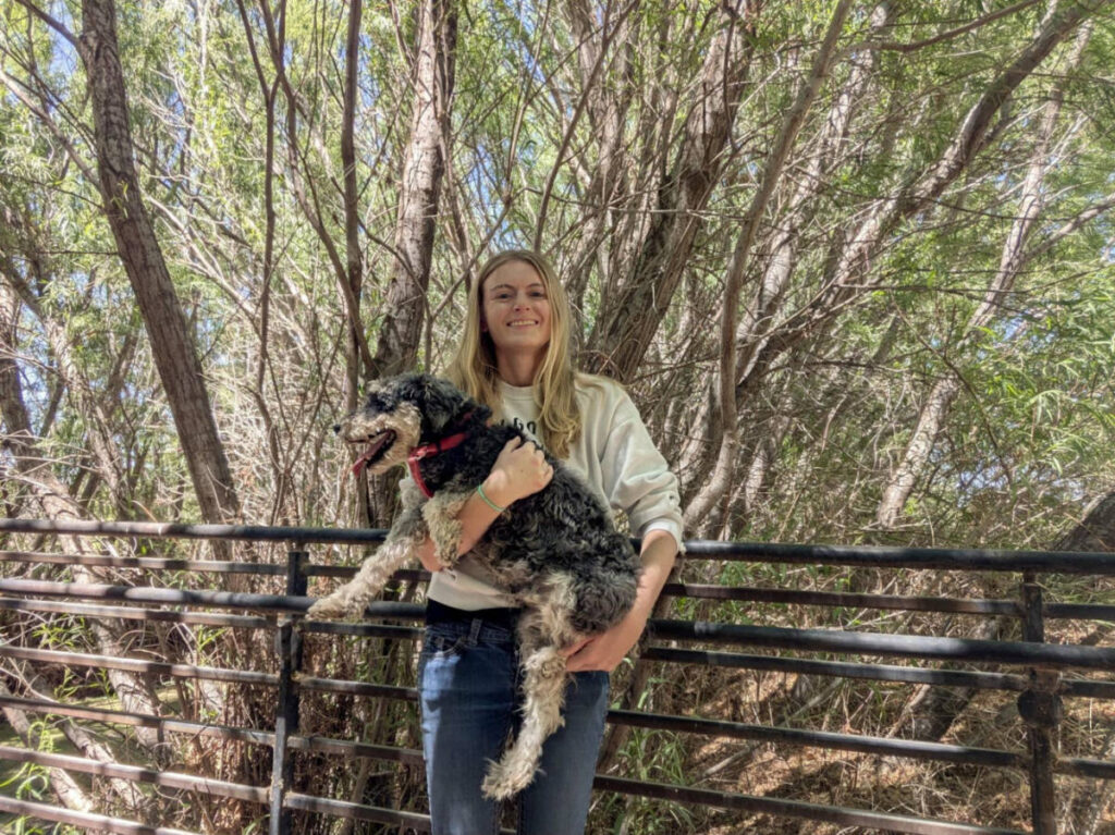 Author Brianna carrying her dog at Rio Bosque Park