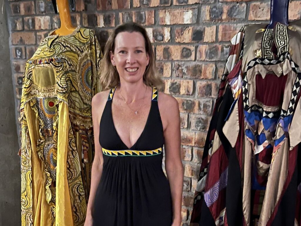 Author Elise standing next to African clothing at a dinner at ‘Gold’ African-themed restaurant