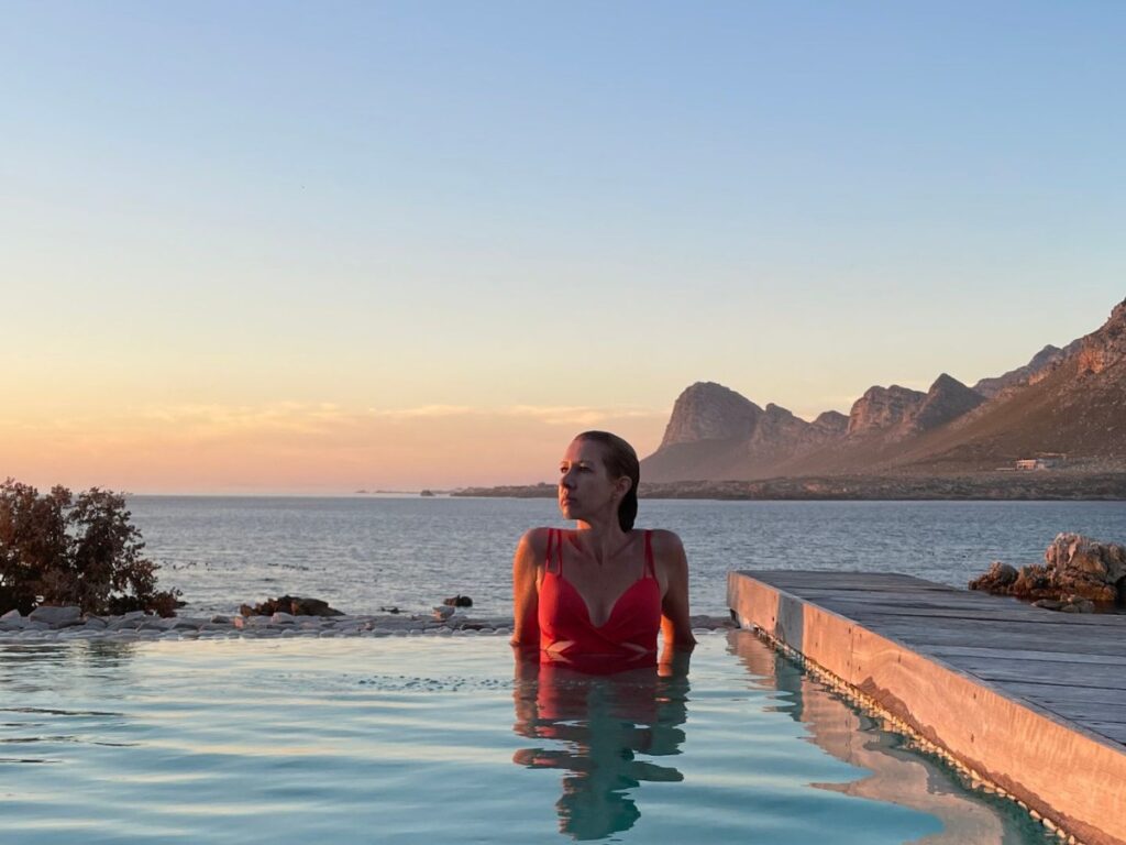 Author Elise enjoying a dip in a rim flow pool overlooking the ocean
