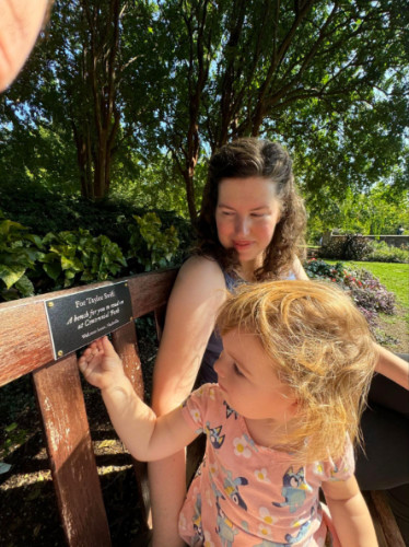 Author Elizabeth and her baby sitting at the Taylor Swift Bench