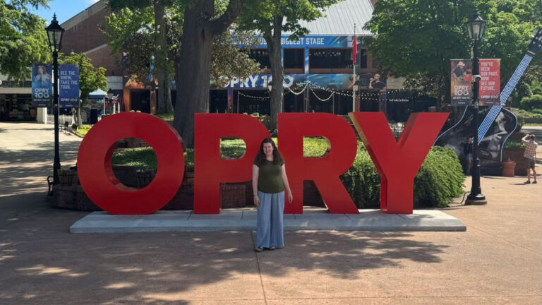 Author Elizabeth standing in front of the Grand Ole Opry sign