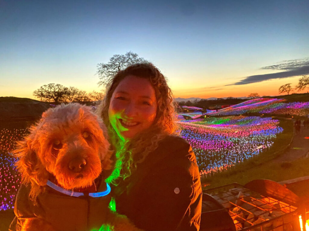 Author Jess and her dog at Sensorio with the field of lights in the background