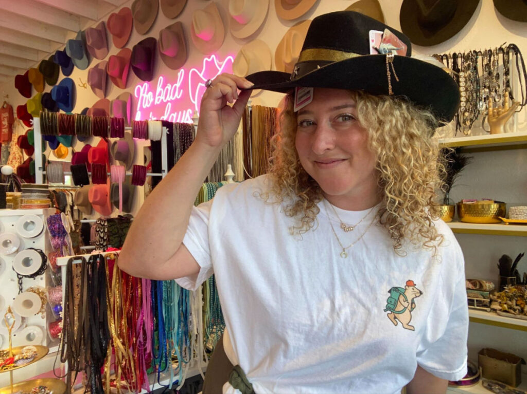 Author Jess trying on hats at Hat Bar