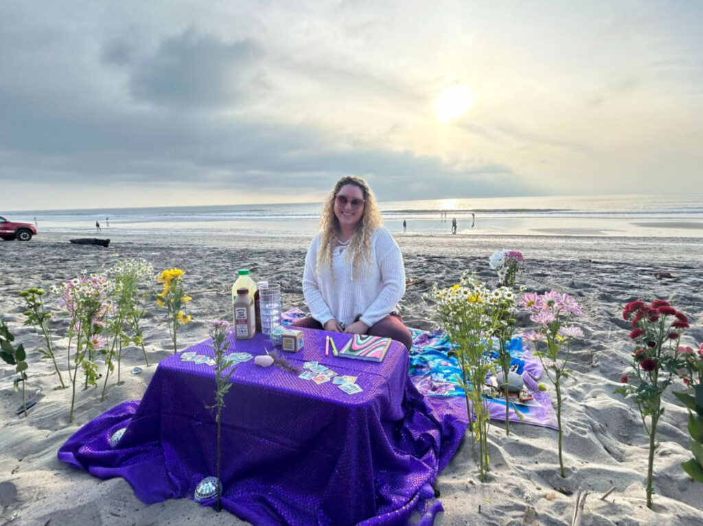 Author Jess hosting a sunset writing and art therapy session on the beach
