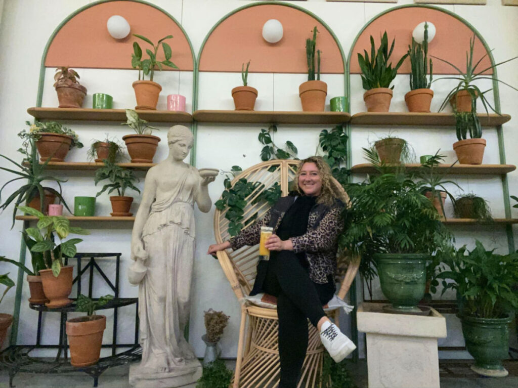 Author Jess sitting on a chair surrounded by plants