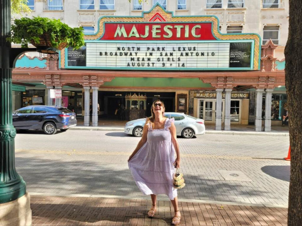 Author Jill smiling brightly in front of The Majestic Theater