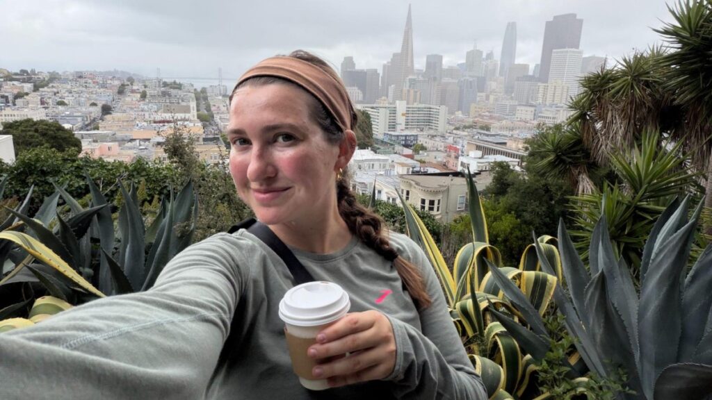 Author Laura taking a selfie at Ina Coolbrith Park with a view of downtown SF
