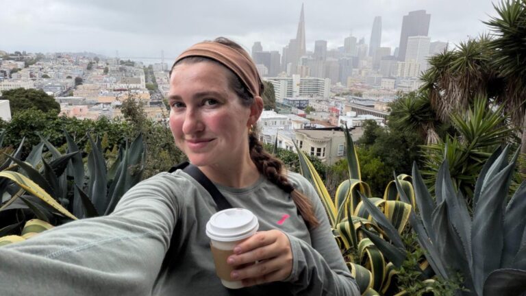 Author Laura taking a selfie at Ina Coolbrith Park with a view of downtown SF