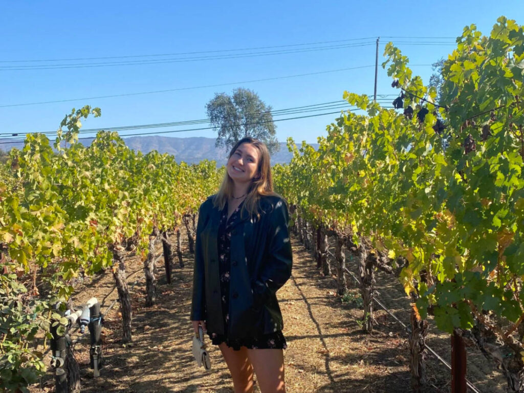 Author Laura standing in the vineyards at Silenus Winery