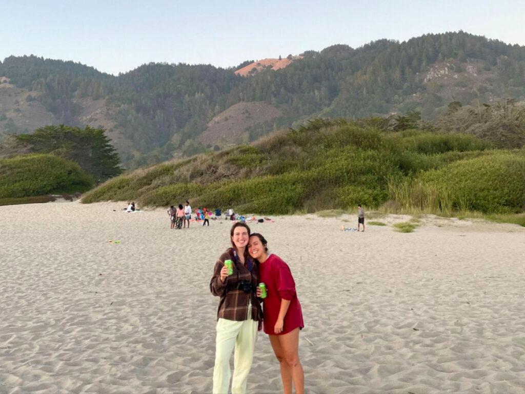 Author Laura and her partner standing on the sands at Stinson with the hills of Mt. Tamalpais behind them