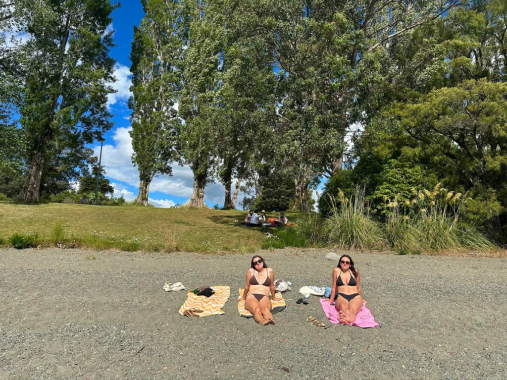 Author Laura and her partner relaxing at a beach in Queenstown