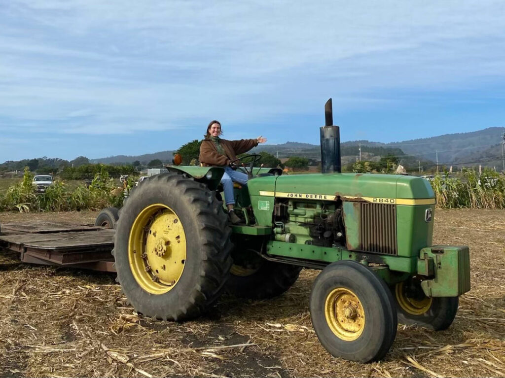 Author Laura sitting on a tractor at a pumpkin patch in Half Moon Bay