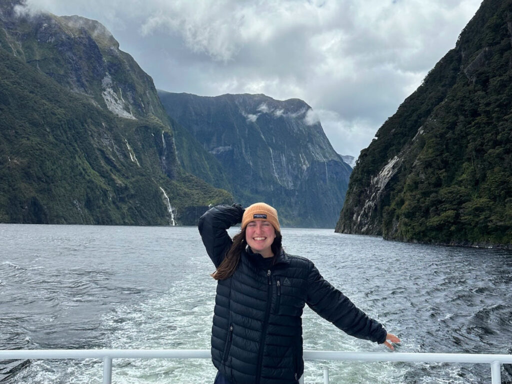 Author Laura wearing puffer jacket and beanie while touring Milford Sound