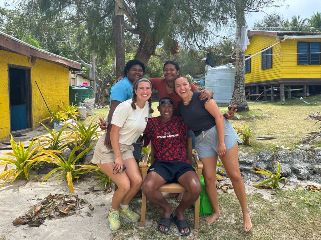 Author Laura smiling brightly with the Fijian family they stayed at