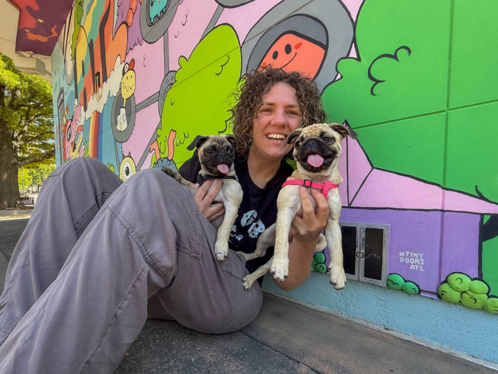 Author Lauren holding her two pugs at Tiny Doors ATL