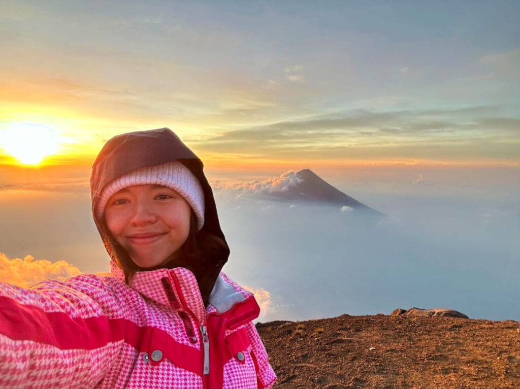 Author Lea Rose at the summit of Acatenango with Agua Volcano in the background