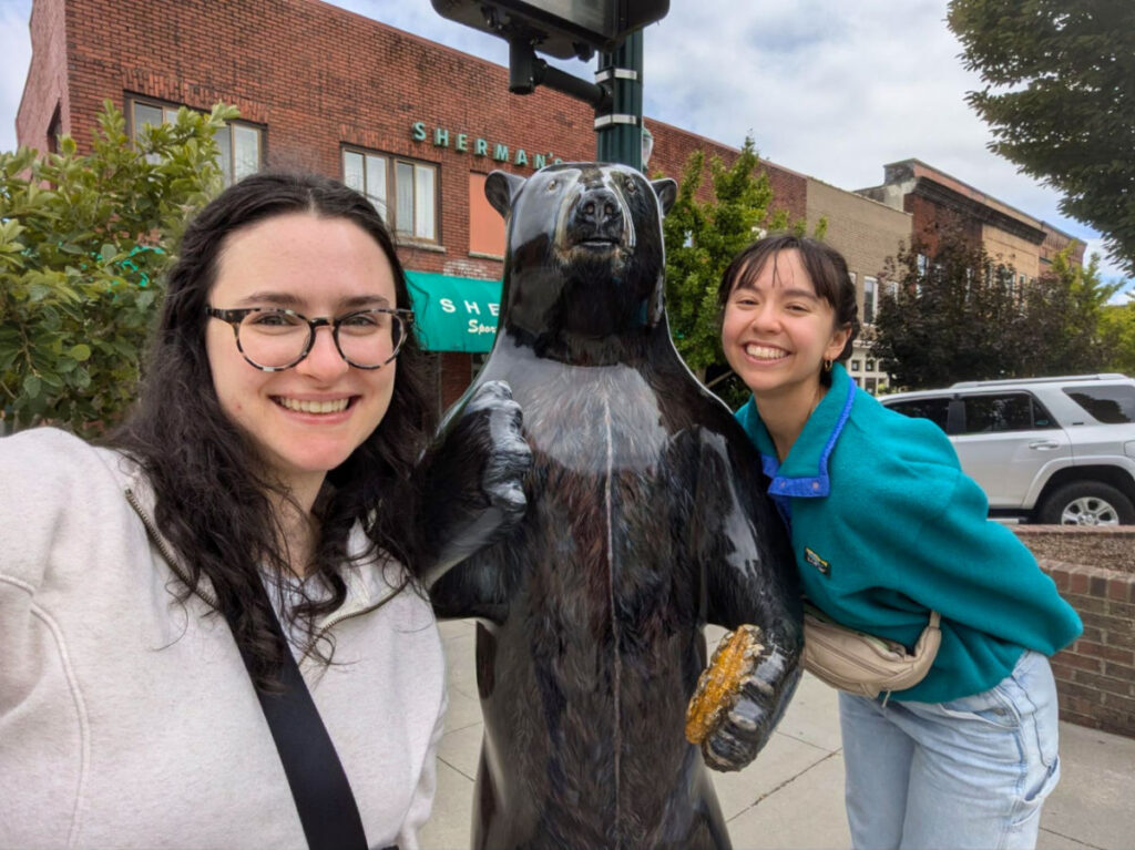 Author Lea Rose and her best friend posing with one of the bears downtown