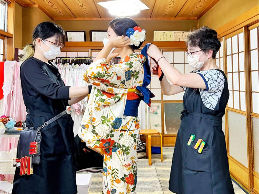 Author Lia being dressed by professional kimono dressers at Kanazawa Kirara