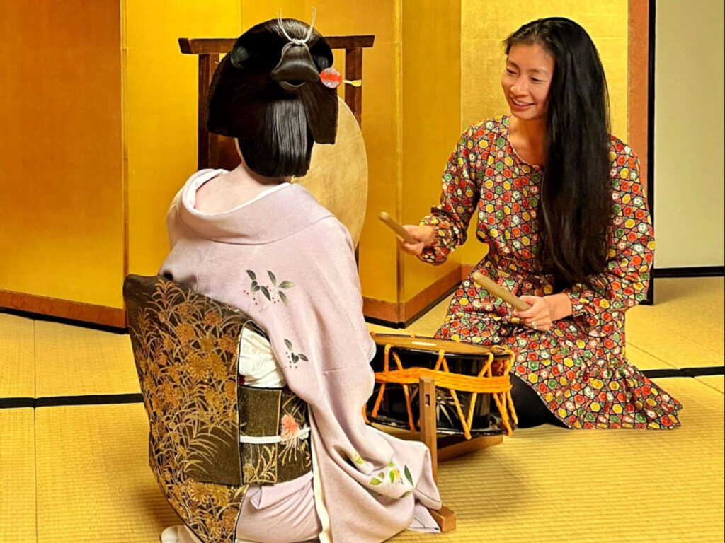 Author Lia playing the drums in front of the Geisha at Kinjohro