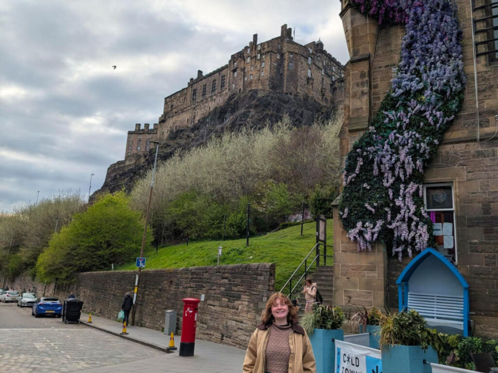 Author Louise standing at Grassmarket Square with Edinburgh Castle above