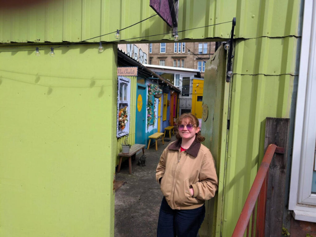 Author Louise standing near the door at a shop in Hidden Lane