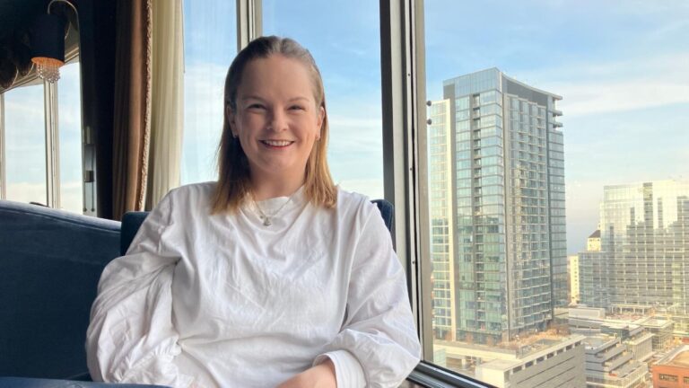Author Rachel smiling brightly at the Pfister Hotel rooftop bar