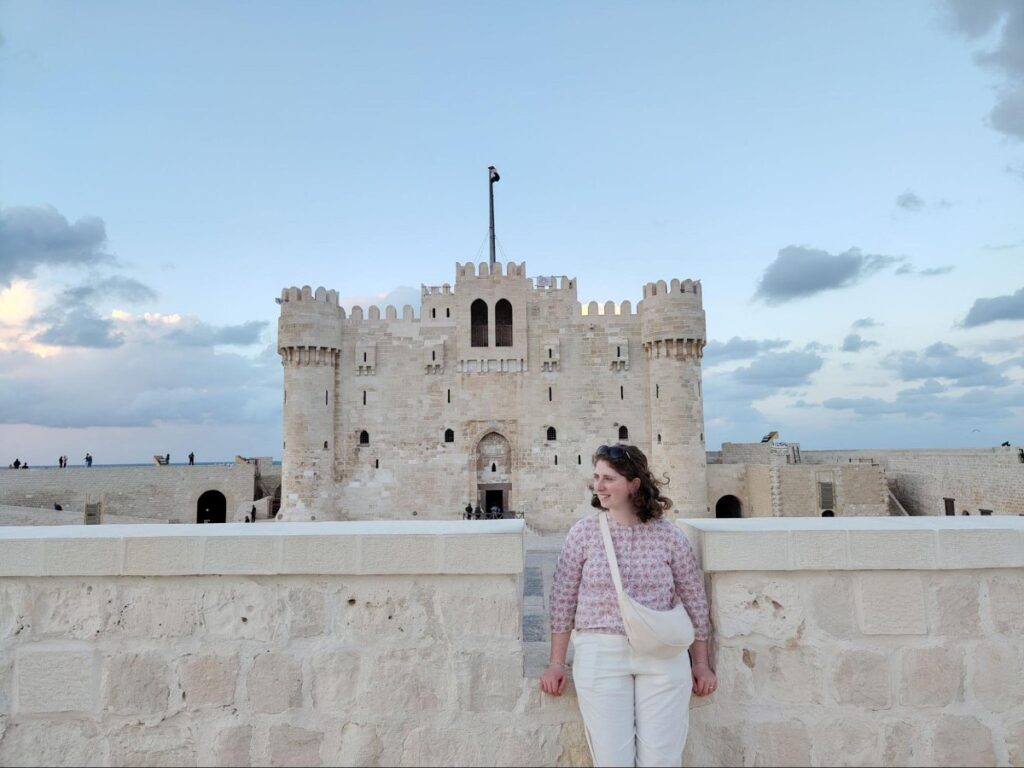 Author Ruthie standing against a stone wall at the Citadel of Qaitbay
