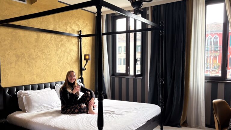 Author Taylor relaxing on the bed at a Carnival Palace suite