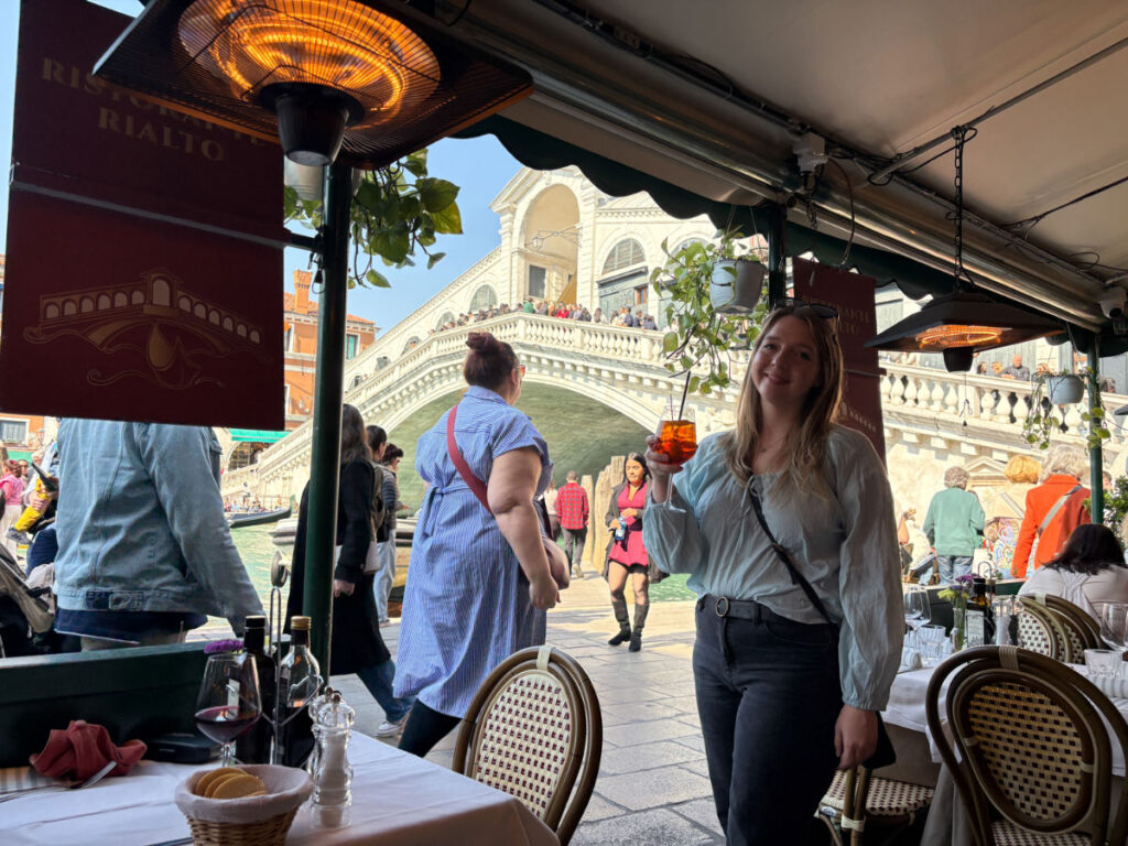 Author Taylor enjoying a drink at Ristorante Rialto with a view of Rialto Bridge at the background