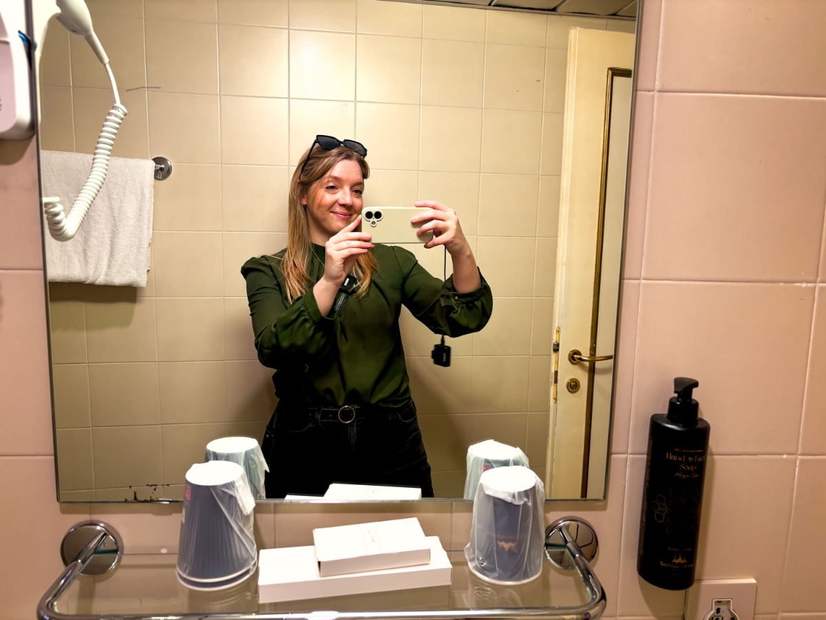 Author Taylor taking a mirror picture at the bathroom of room 307