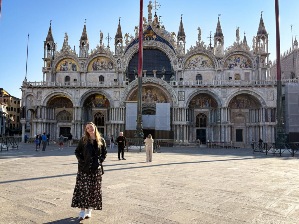 Author Taylor standing in front of St. Mark’s Basilica in Piazza San Marco