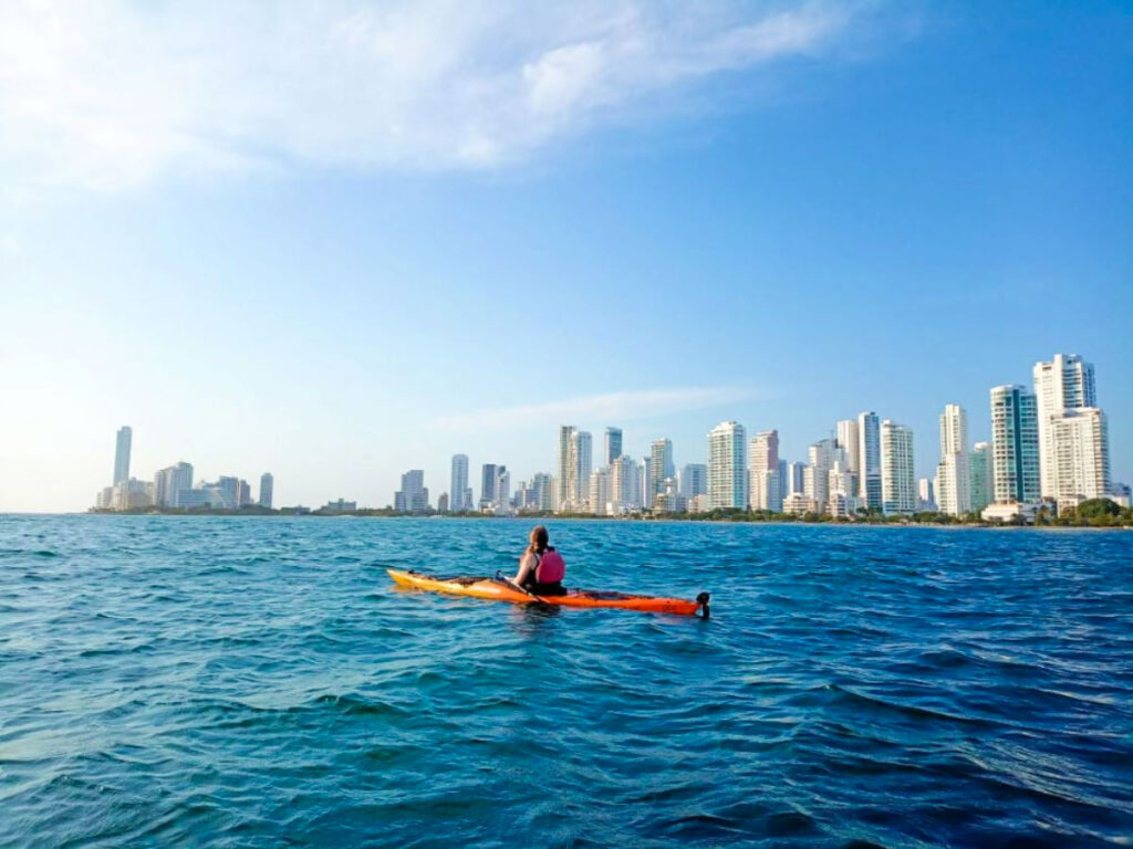 Author Taylor kayaking off the coast of Cartagena with a view of the buildings in the background