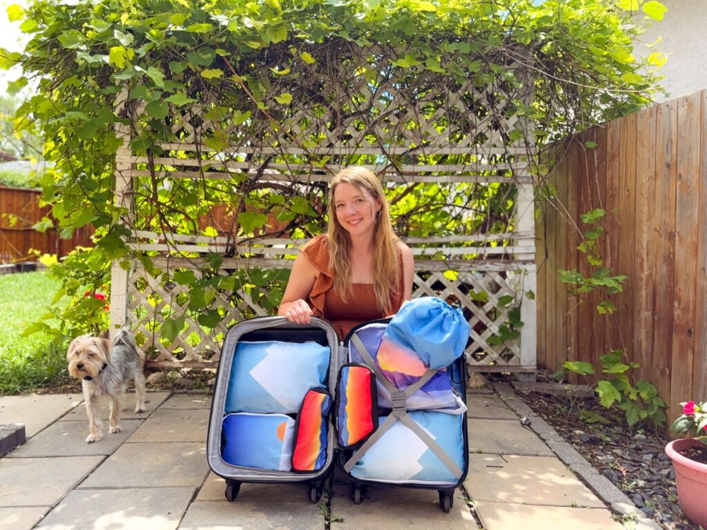 Author Taylor showing her luggage filled with packing cubes