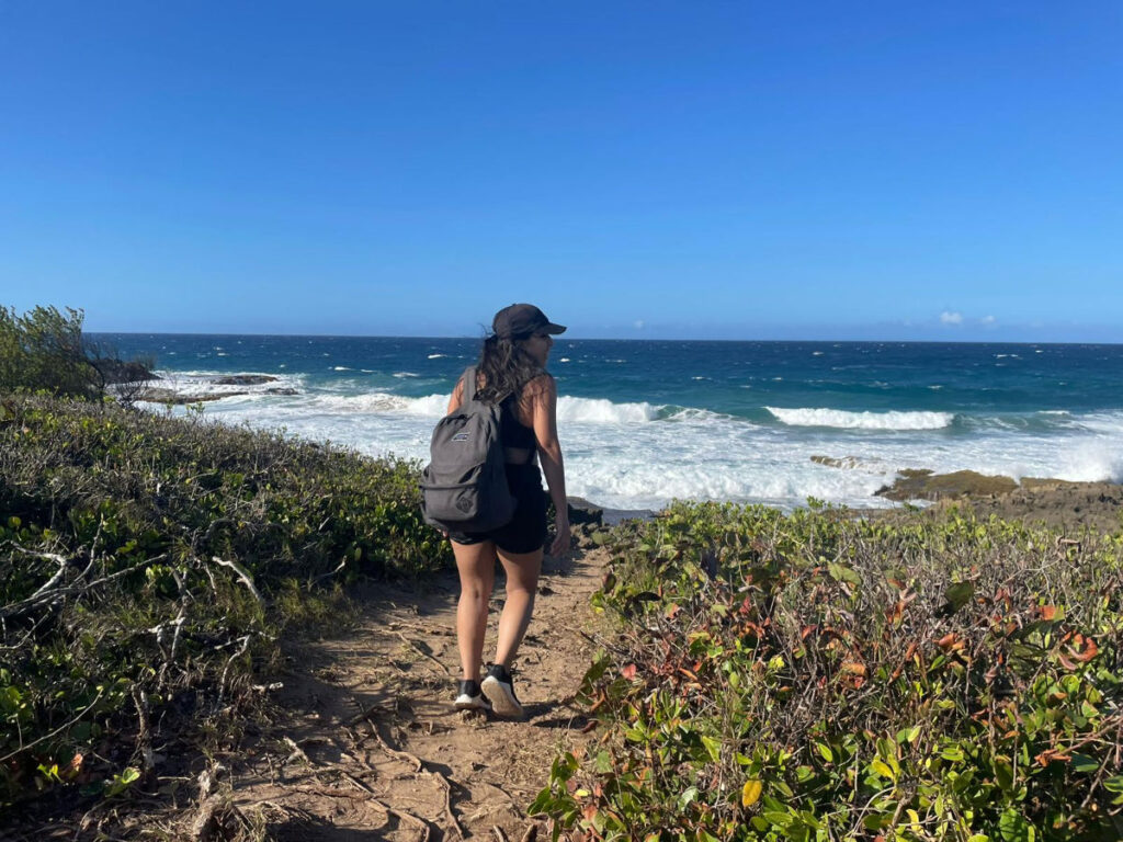Author Vanessa with a backpack and cap heading to the sea