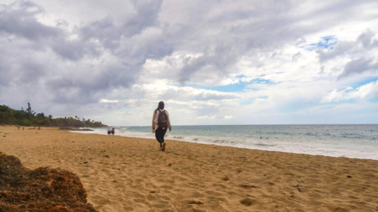 Author Vanessa walking on a beach in Aguadilla