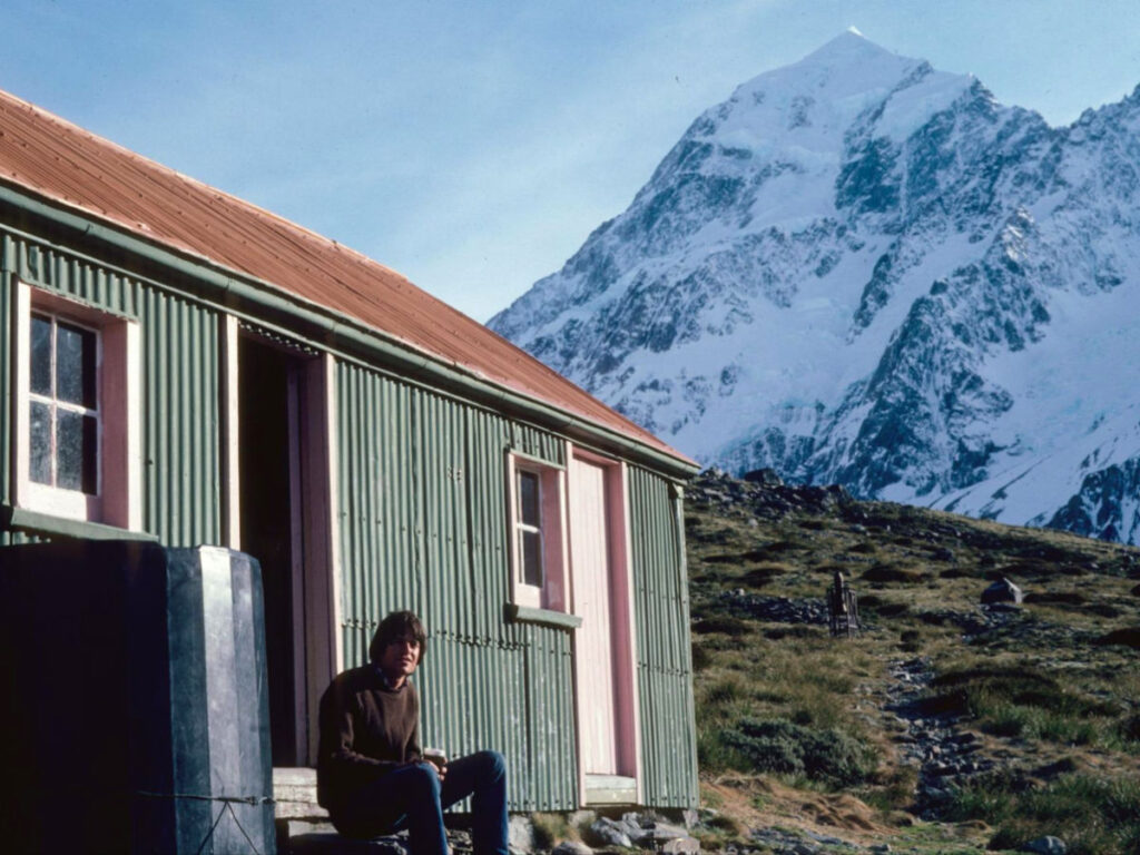 Author's dad sitting outside a backcountry hut while hiking on Mt. Cook