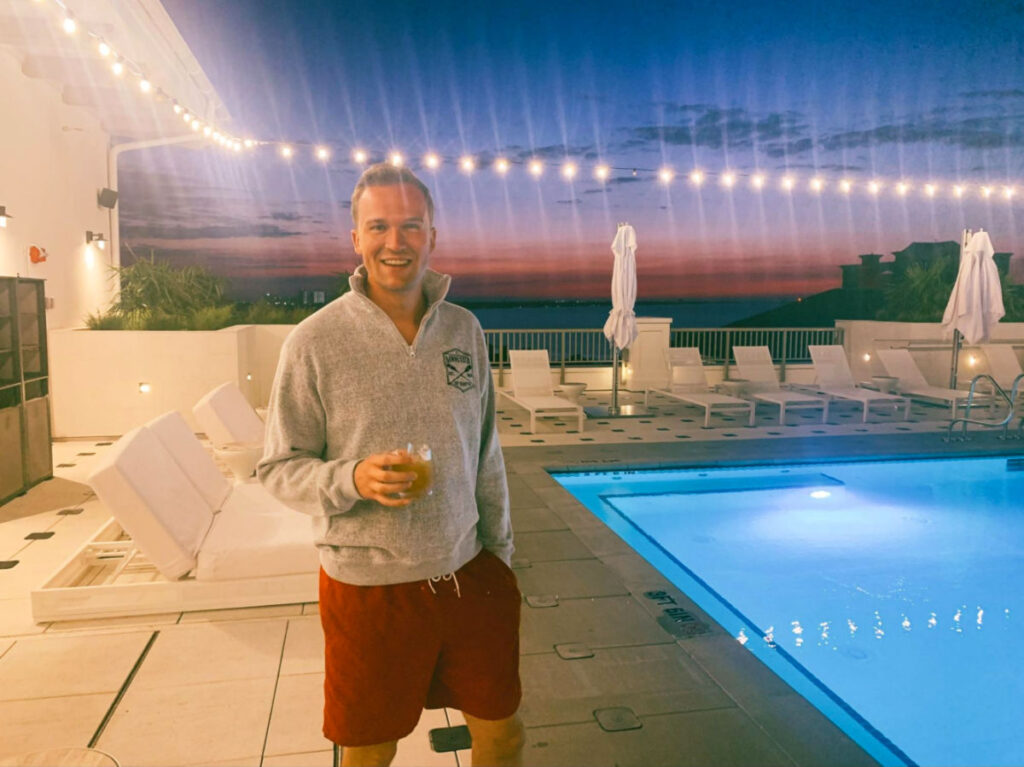 Author's husband holding a drink at the Hotel Effie’s Ara Rooftop Pool