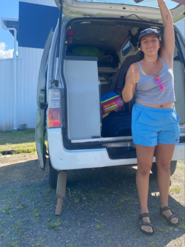 Author's partner at the back of a campervan showing what happened to the tailpipe