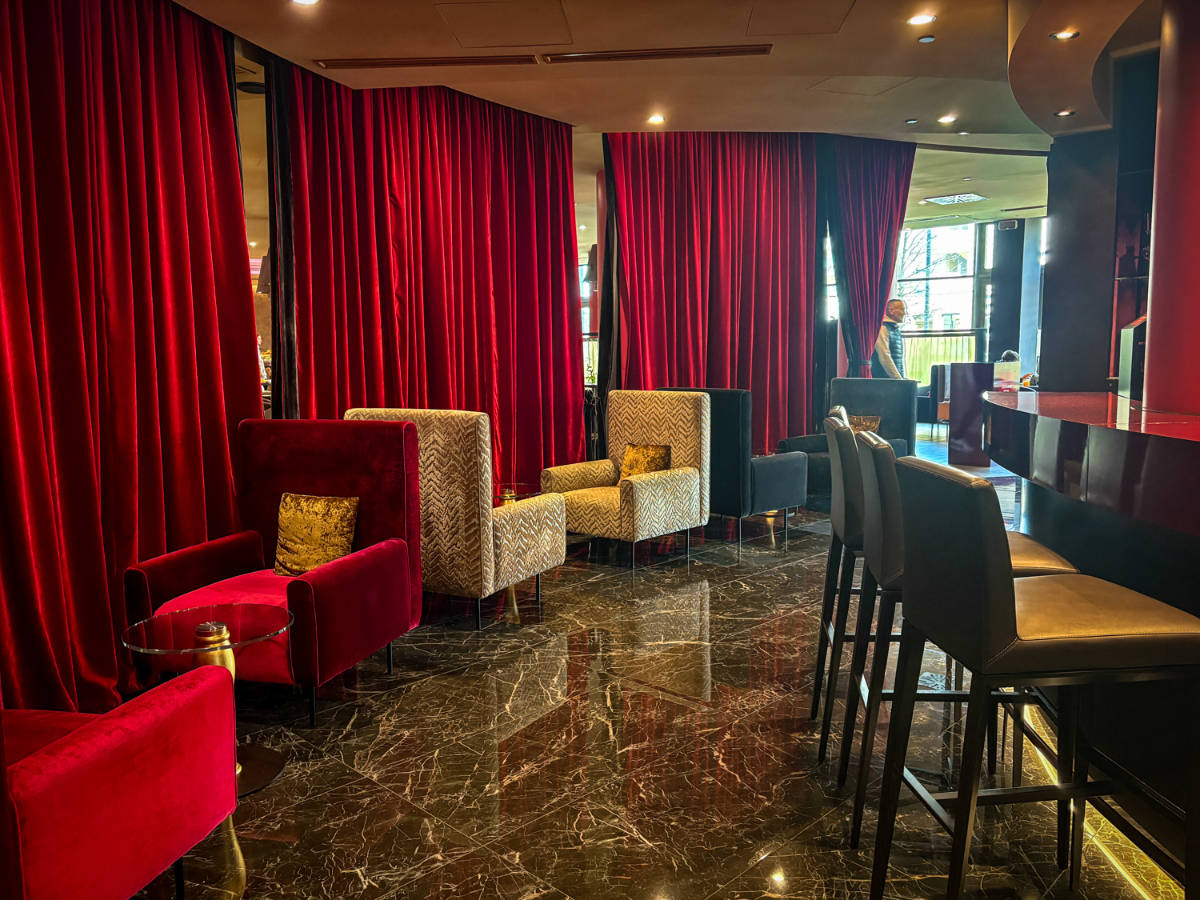 Chairs and tables inside a bar in Leonardo Royal Hotel Mestre