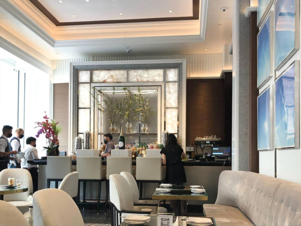 View of the interior and busy bar area at Trifecta in the Four Seasons Hotel One Dalton